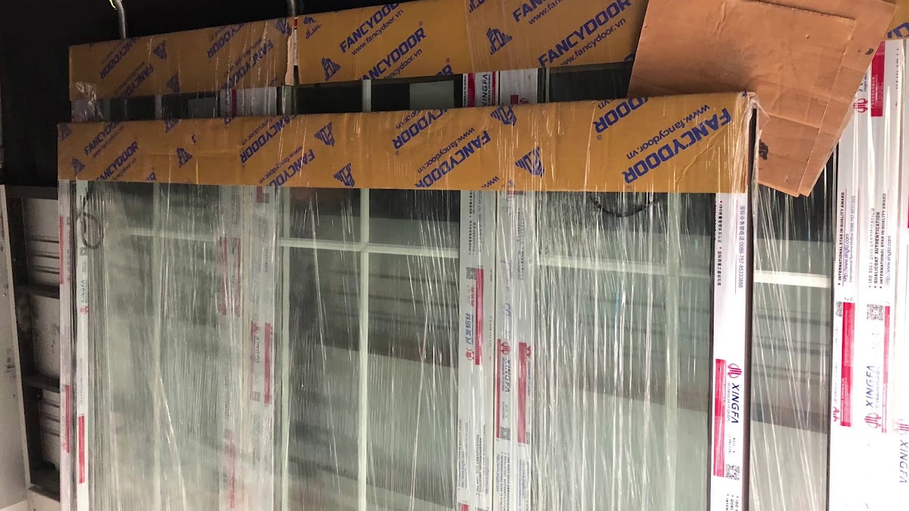 Cửa nhôm kính Xingfa mới bọc nilon và thùng carton chuẩn bị lắp đặt